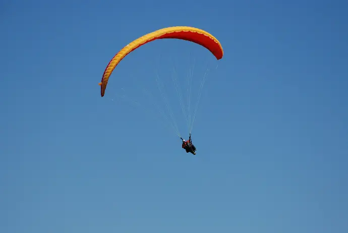 a person is parasailing in the blue sky